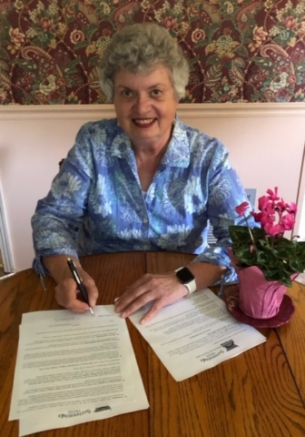 Delores Topliff signs contracts for Books Afloat and Wilderness Wife