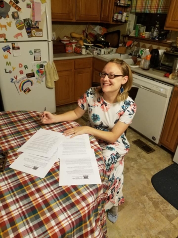 Amy Anguish signs a contract for Candy Cane Wishes and Saltwater Dreams novella collection