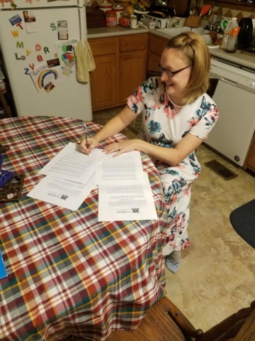 Amy Anguish signs a contract for No Place Like Home
