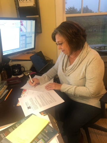 Regina Merrick signs a contract for Candy Cane Wishes and Saltwater Dreams novella collection