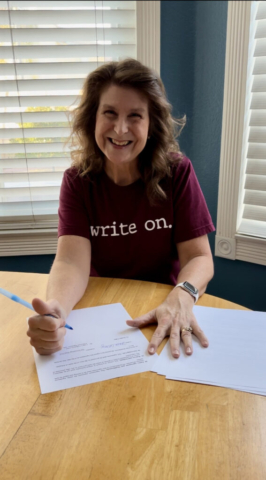 Denise Colby signing contract for Best-laid Plans series.