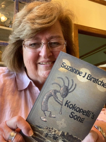 Deborah Sprinkle holding Kokopelli's Song by Suzanne Bratcher